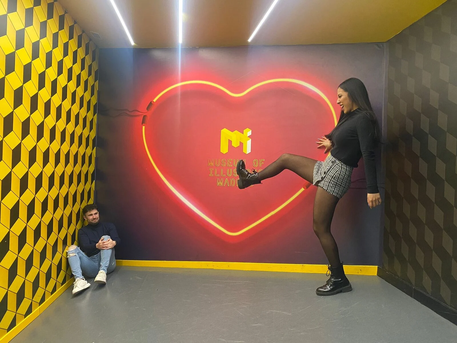 Catalina y David en el Museum of Illusions de Madrid, ante un corazón de neón