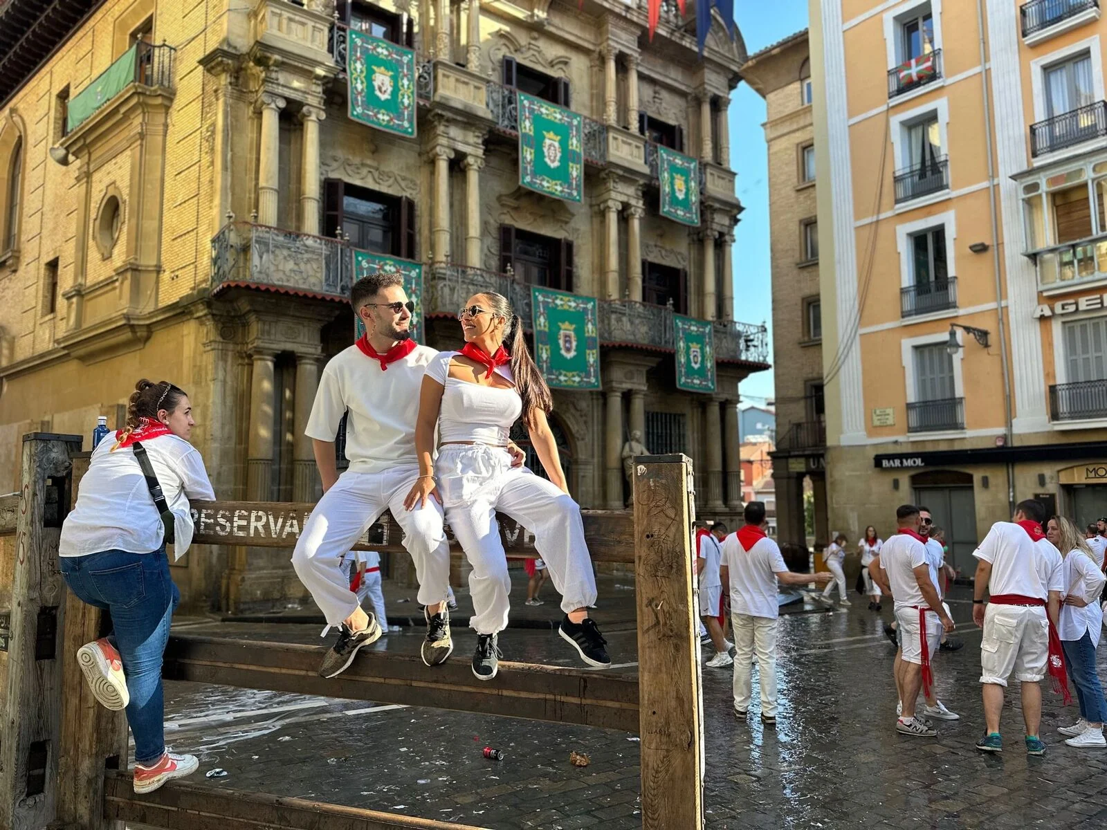 Catalina y David de blanco y rojo entre la gente, en San Fermín