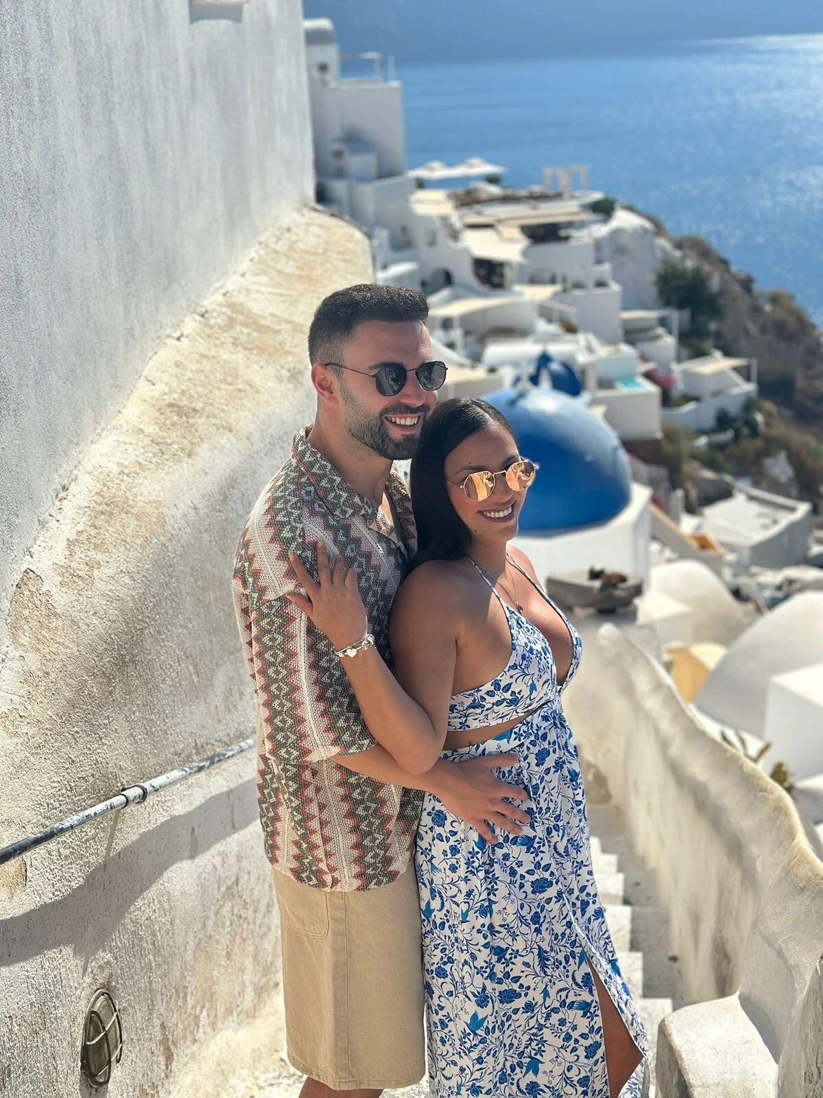 Catalina y David en unas escaleras de Oia, sobre las casas blancas