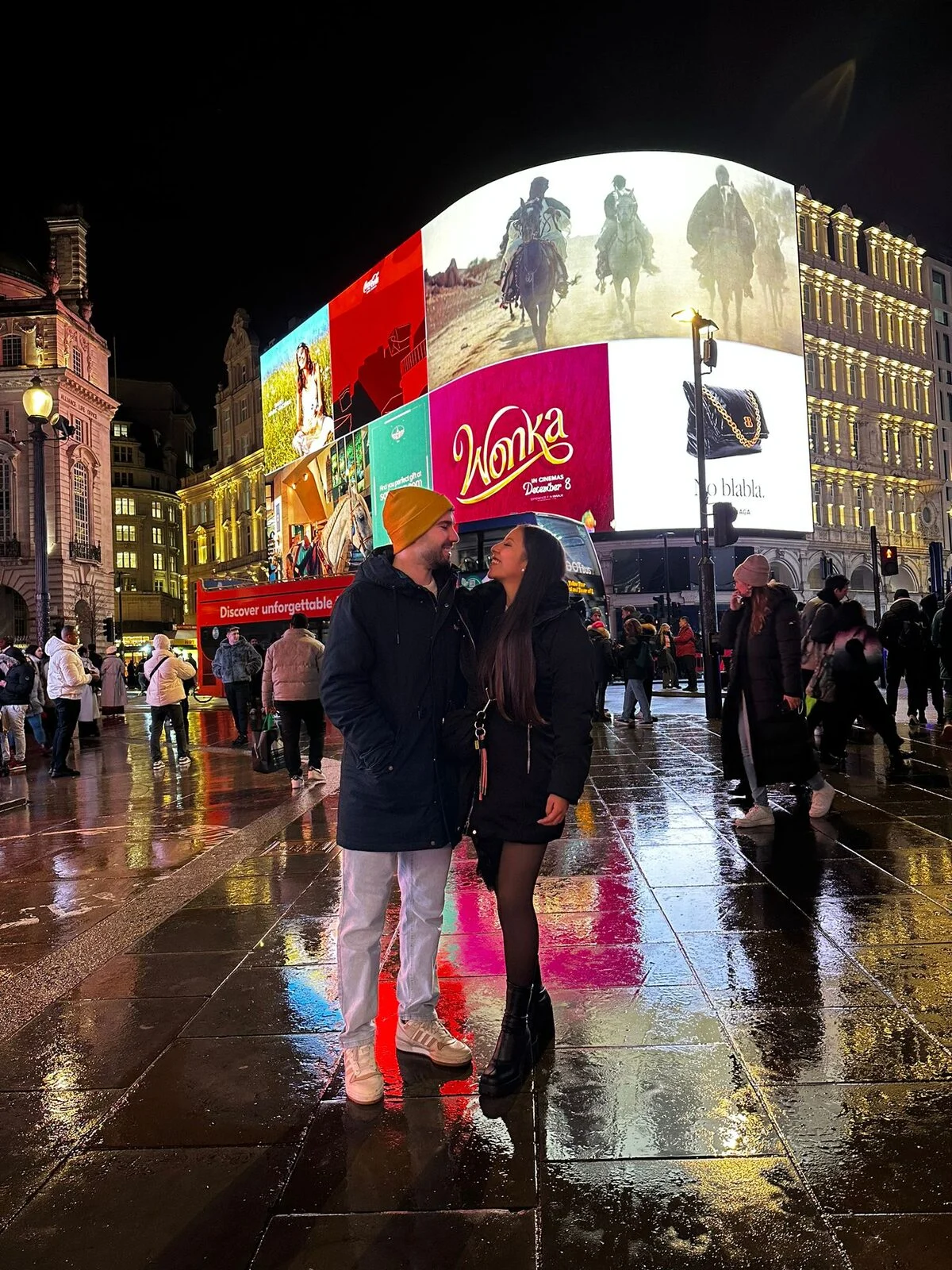 Catalina y David en Piccadilly Circus, con las pantallas encendidas detrás